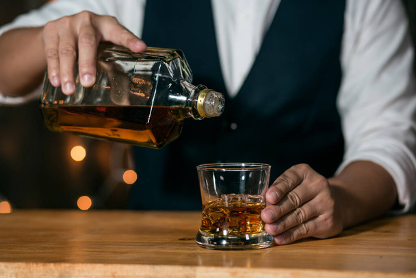 Barman versant whisky verre belle nuit - Photo, image