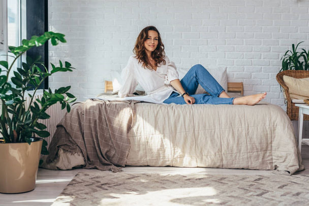Retrato de una joven en el dormitorio sobre la cama - Foto, imagen