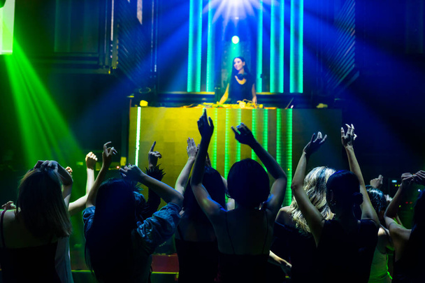 Silueta imagen de la gente bailando en discoteca discoteca con música de DJ en el escenario - Foto, Imagen
