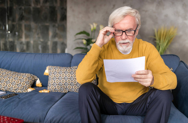 Adult man reading letter with confused face from social service - Foto, Imagem