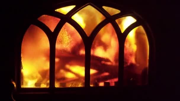 Um fogo tempestuoso em um fogão em casa queima para aquecer o quarto - Filmagem, Vídeo