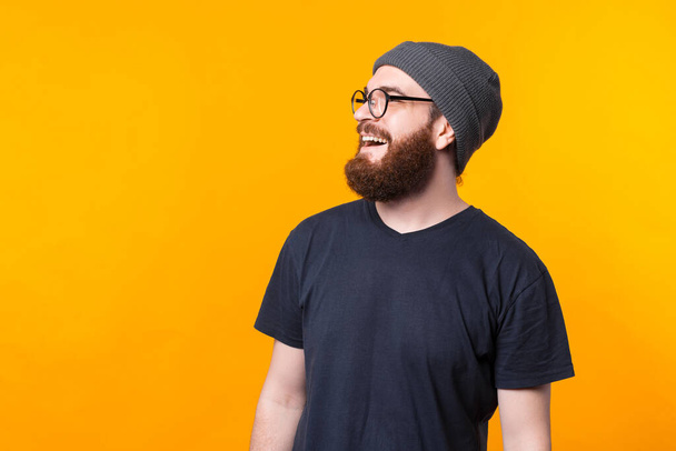 A side profile portrait of a bearded man with glasses looking and smiling away - Photo, Image