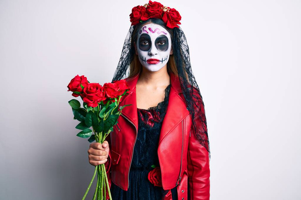 Ölü kostümü giymiş bir kadın elinde güllerle düşünceli bir tavırla ve ayık bir ifadeyle kendinden emin görünüyor.  - Fotoğraf, Görsel