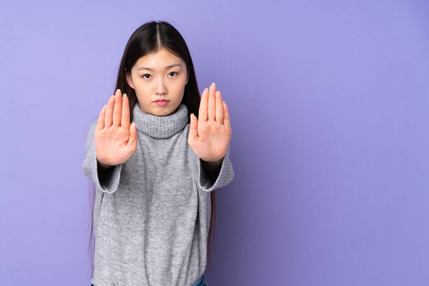 Young asian woman over isolated background making stop gesture and disappointed - Photo, Image