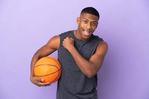 若いですバスケットボールラテン選手男隔離上の紫の背景祝うA勝利 - 写真・画像