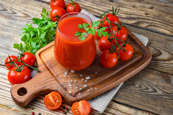  Glass of fresh tomato juice and tomatoes on the wooden background - Valokuva, kuva