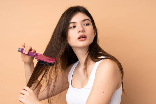 Giovane ragazza adolescente ucraina su sfondo isolato con pettine capelli - Foto, immagini