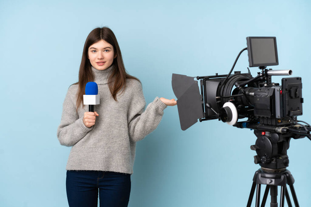 Junge Reporterin hält ein Mikrofon in der Hand und berichtet Nachrichten, die imaginäre Kopien auf der Handfläche halten - Foto, Bild