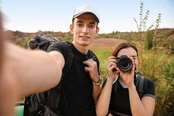 Couple of young tourists taking selfie in countryside - Photo, Image
