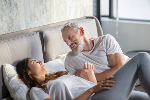 Man and woman lying on bed communicating - Photo, Image
