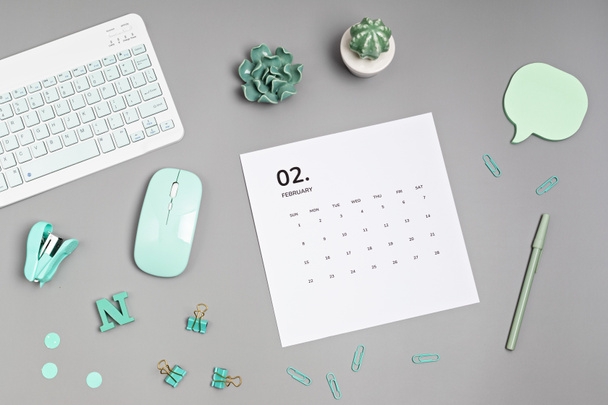 Επιφάνεια εργασίας με ημερολόγιο για τον Φεβρουάριο και προμήθειες γραφείου - Φωτογραφία, εικόνα