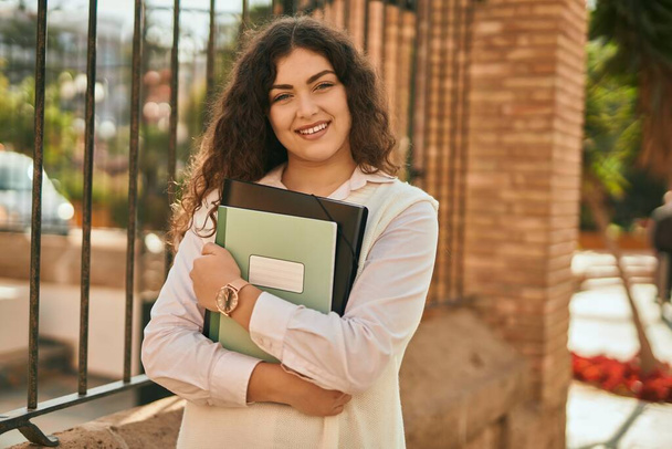 Genç İspanyol öğrenci kadın gülümseyerek şehirde mutlu mesut duruyor.. - Fotoğraf, Görsel