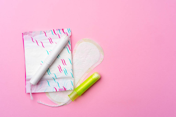 Female hygienic pad and tampons on pink background - Фото, изображение