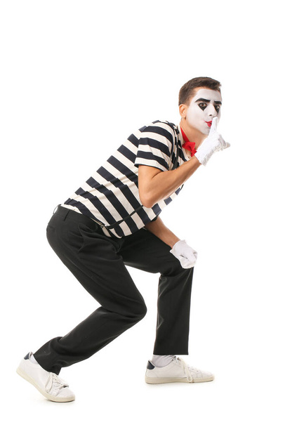 Pantomimista masculino mostrando gesto de silencio sobre fondo blanco - Foto, imagen