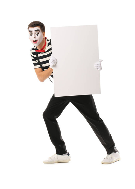 Pantomimiste masculin avec affiche vierge sur fond blanc - Photo, image