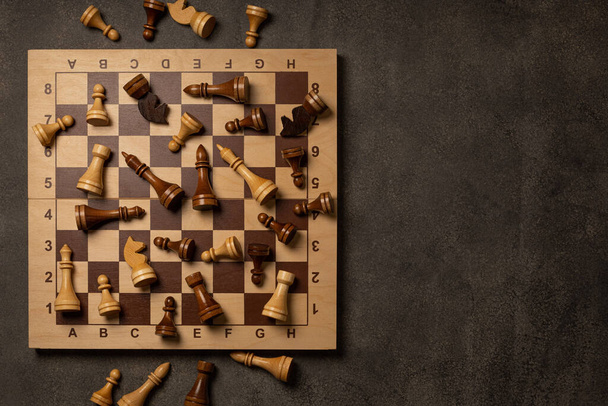 Chess pieces are scattered chaotically on a chessboard - Fotografie, Obrázek