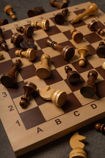 Chess pieces are scattered chaotically on a chessboard - Zdjęcie, obraz