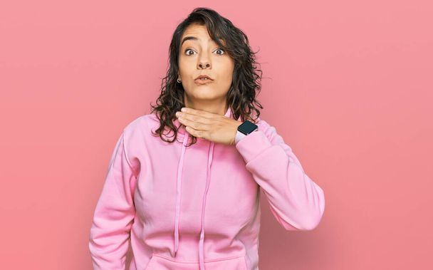 Fiatal spanyol nő alkalmi pulóvert visel elvágja a torkát kézzel, mint kés, fenyegető agresszió dühös erőszak  - Fotó, kép