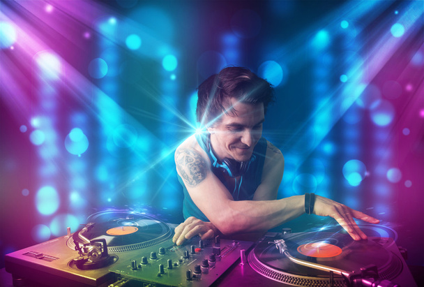 Dj mixing music in a club with blue and purple lights - Photo, Image