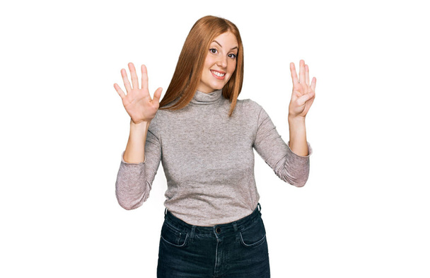Молода ірландка в повсякденному одязі показує і вказує пальцями номер дев'ять, посміхаючись впевнено і щасливо
.  - Фото, зображення