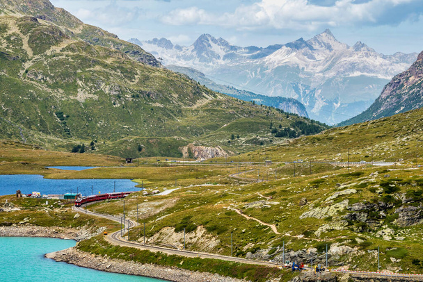 Tren Bernina Express en el Lago Blanco en Ospizio Bernina, Upper Engadin, Graubuenden, Grisons, Suiza. - Foto, imagen