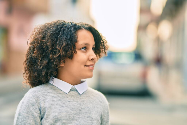 Adorável criança hispânica menina sorrindo feliz de pé na cidade. - Foto, Imagem