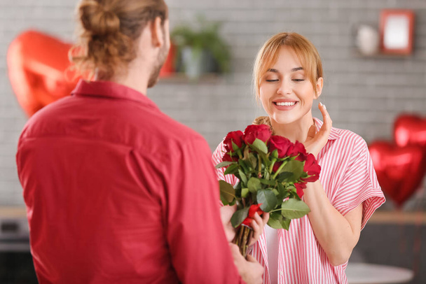 Молодой человек приветствует свою девушку в День Святого Валентина дома - Фото, изображение