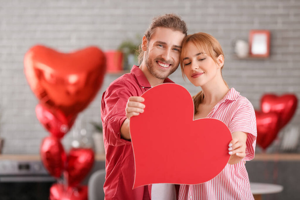 Young couple celebrating Valentine's Day at home - Фото, изображение