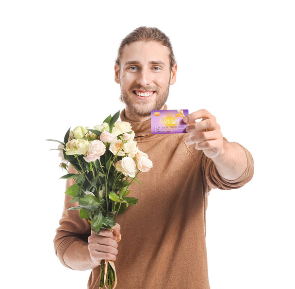 Przystojny młody człowiek z kartą podarunkową i kwiatami na białym tle - Zdjęcie, obraz