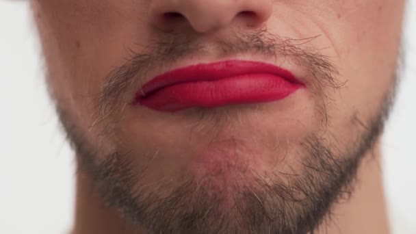 Adult beauty man with black beard, moustache wear makeup  red lipstick, purses his lips, doubts, denies gesture. Close up alone handsome metrosexual or gay male mouth on white background. - Metraje, vídeo