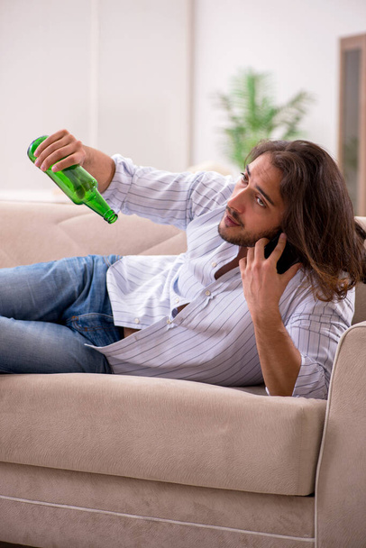 Fiatalember alkoholt iszik otthon. - Fotó, kép