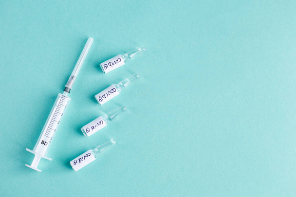 Ampollas con vacuna Covid-19 sobre fondo azul. Concepto de vacunación - Foto, Imagen