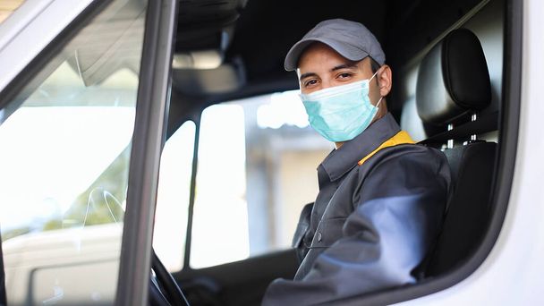 Smiling deliverer man driving a van, covid coronavirus concept - Zdjęcie, obraz