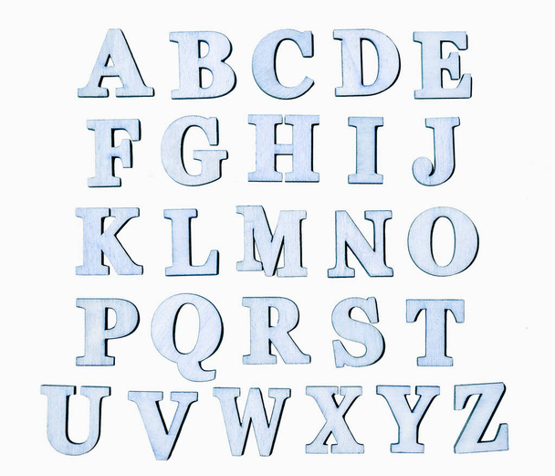 Zestaw klasycznych, niebieskich, drewnianych liter, odizolowanych na białym tle. Angielski symbol alfabetu dla tekstu. - Zdjęcie, obraz