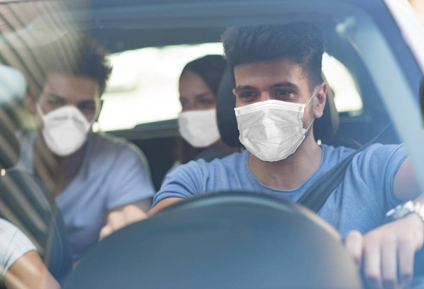 Group of friends driving in a car, covid coronavirus concept - Photo, Image