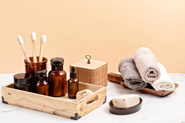 Bambusz és üveg kiegészítők fürdőkádhoz - edények, szappantartó, kefék a személyes higiéniához. Zéró hulladék, szerves, műanyag mentes, fenntartható dekoráció fürdőszobához - Fotó, kép