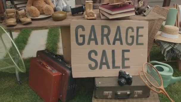  Colpo dolly-out palmare di diversi beni di seconda mano in vendita garage nel cortile anteriore della casa suburbana - Filmati, video