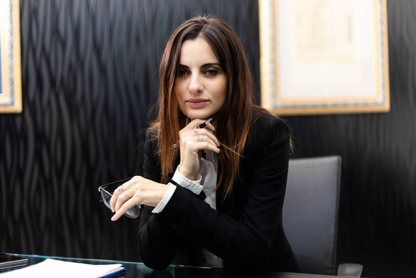 Young female manager sitting a the desk in a modern office - Φωτογραφία, εικόνα