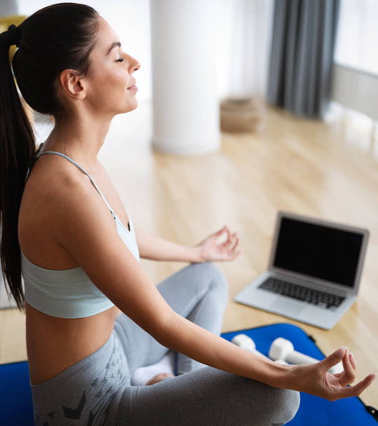 Beautiful young woman doing yoga, workout at home. - Foto, Imagen