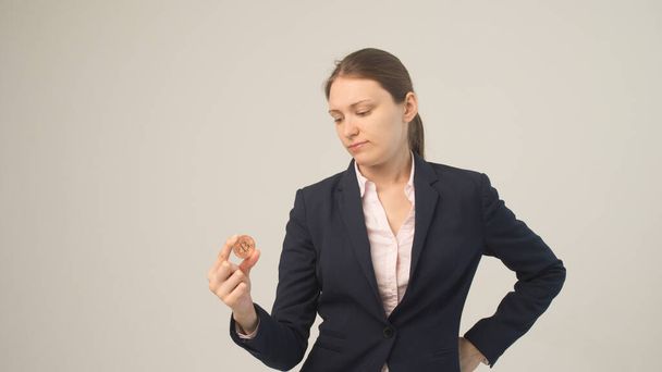 Mujer de negocios sosteniendo una criptomoneda bitcoin física en su mano - Foto, Imagen
