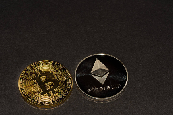 zwei wertvolle Kryptowährungsmünzen Bitcoin und Äther auf schwarzem Hintergrund oben - Foto, Bild