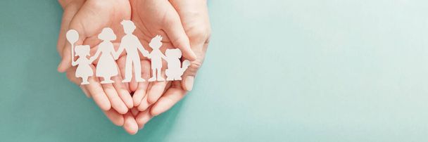 hands holding paper family cutout, family home, foster care, homeless support, social distancing, world mental health day, Autism support,homeschooling education, lockdown concept - Foto, Imagen