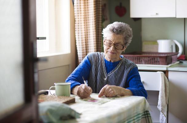 Old woman in the kitchen - Фото, зображення