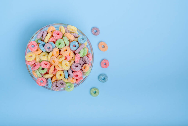 Colored fruit grain loops in a glasses. types of colored loops. top view. on a blue background. High quality photo - Φωτογραφία, εικόνα