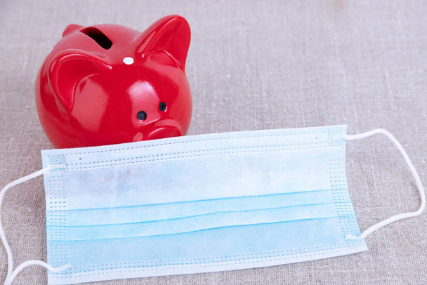 Piggy Bank With Medical Mask To Illustrated Costs Of Healthcare. - Photo, Image