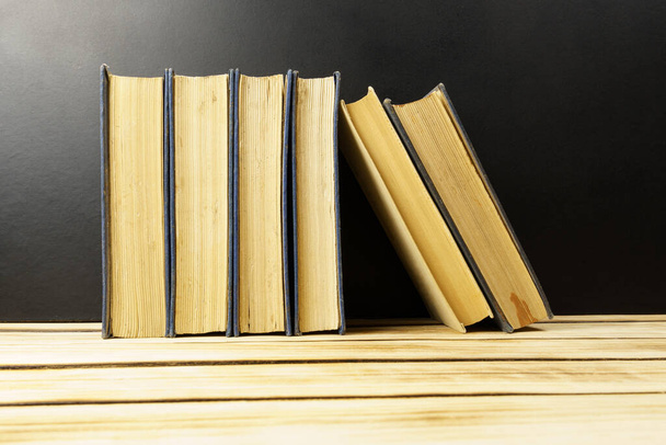 Stare, stare książki na drewnianym tle. Kontekst z książek. Edukacja. Światowy Dzień Książki - Zdjęcie, obraz