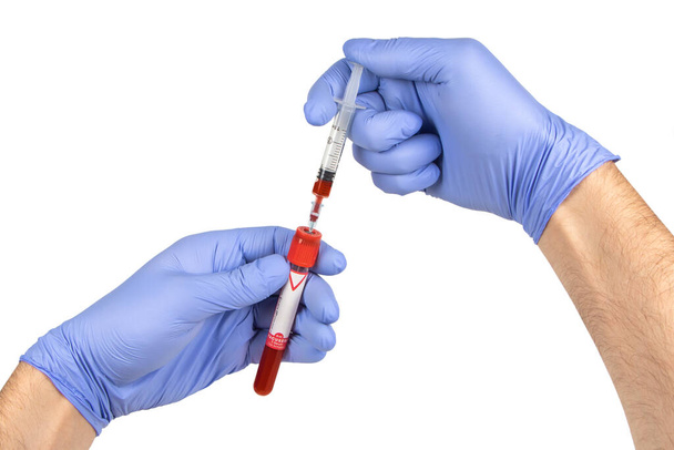 Γιατρός εγχέει ένα δείγμα αίματος σε μια ανάλυση δοκιμαστικό σωλήνα. - Φωτογραφία, εικόνα