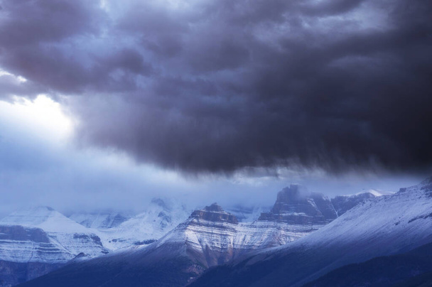 Luontovoima tausta - pimeä myrskyinen taivas lumisilla vuorilla - Valokuva, kuva