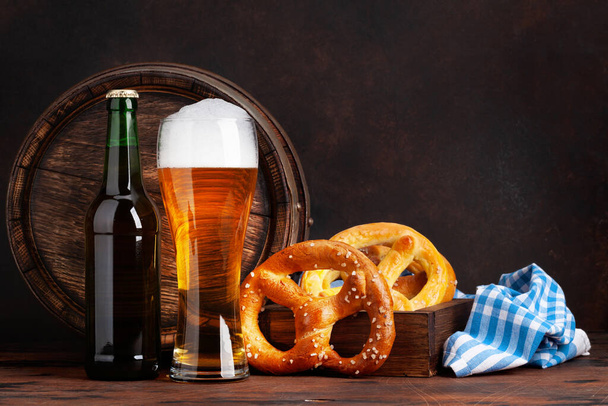 Lager olutta kotitekoisia suolarinkeleitä ja vanha puinen oluttynnyri. Kopioi tilaa - Valokuva, kuva