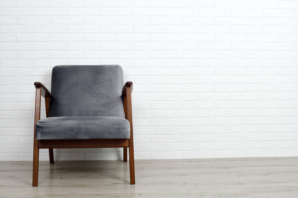 Grey armchair on white brick wall background - Foto, Imagen